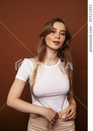 young pretty girl with blond hair posing cheerful on brown background, lifestyle people concept 85521051