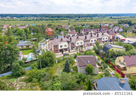 Aerial photography, suburban residential areas on a summer day, two-story townhouses amid country houses and fresh green vegetation. Aerial photography, suburban residential areas on a summer day, two-story townhouses amid country houses and fresh green vegetation. 85521161