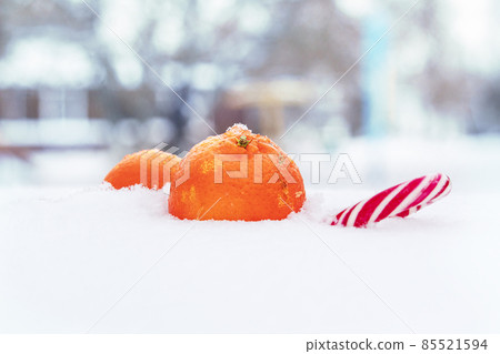 Fresh ripe mandarin, tangerine or clementine isolated on white snow in winter. Fresh ripe mandarin, tangerine or clementine isolated on white snow in winter. 85521594