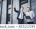 Working in the newnormal, the project engineer and the team leader wear masks. and consulting on the building's solar cell system.engineers team discuss the use of solar energy in modern buildings. 85521595