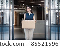 portrait of a female company employee standing outdoor with box of stuff. Leaving business. Female office worker lost her job.Job loss due to COVID-19 virus pandemic concept 85521596