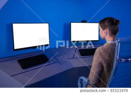 Woman looking at two monitors with white displays - mock up concept Woman looking at two monitors with white displays - mock up concept 85521970