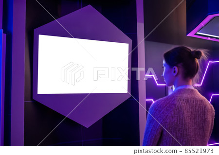 Woman looking at blank white display wall at exhibition - white screen concept Woman looking at blank white display wall at exhibition - white screen concept 85521973