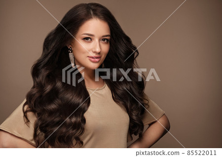 Beautiful brown-haired girl with a perfectly curls hair, and classic make-up. Beauty face and hair. 85522011