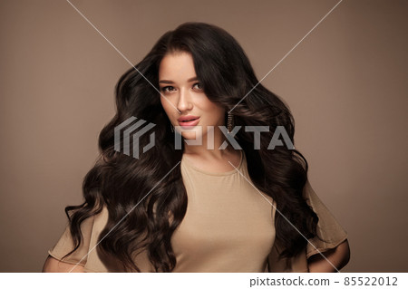 Beautiful brown-haired girl with a perfectly curls hair, and classic make-up. Beauty face and hair. 85522012