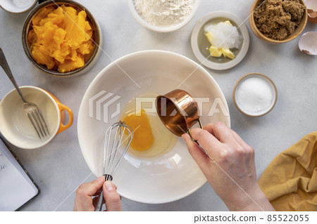Process of cooking pumpkin cake, muffins or pumpkin dessert. Top view. Female hands. Step by step recipe. 85522055