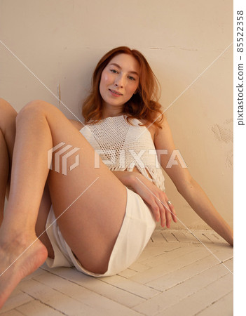 Young white european woman with beige wall behind Young white european woman with beige wall behind 85522358
