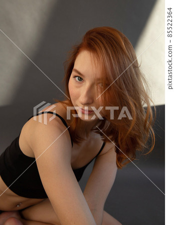 Young white european woman with grey wall behind Young white european woman with grey wall behind 85522364