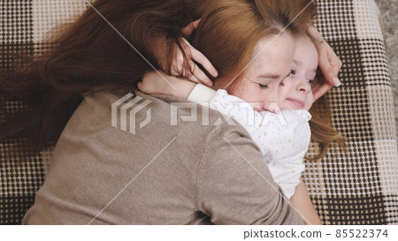 Happy mom hugs the baby while lying on the sofa in the children's room and smiles. Mother and daughter love in family relationships concept. Parental care and care of the kid. Your favorite baby will Happy mom hugs the baby while lying on the sofa in the children's room and smiles. Mother and daughter love in family relationships concept. Parental care and care of the kid. Your favorite baby will 85522374