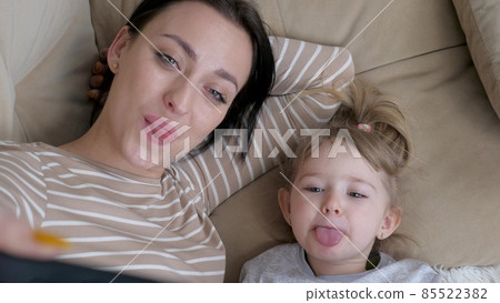 Authentic close up of neo mother and her baby making a selfie or video call to father or relatives in a bed. Shot in 8K. Concept of technology, new generation,family, connection, parenthood Authentic close up of neo mother and her baby making a selfie or video call to father or relatives in a bed. Shot in 8K. Concept of technology, new generation,family, connection, parenthood 85522382