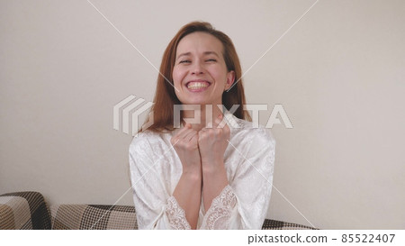 Happy woman in the distance chatting by video call. Smiling young girl talking and laughing while looking at the webcam during a virtual online meeting. Listen to a webinar lecture. View your computer Happy woman in the distance chatting by video call. Smiling young girl talking and laughing while looking at the webcam during a virtual online meeting. Listen to a webinar lecture. View your computer 85522407