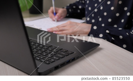 Businesswoman prints a document on a laptop and writes records in a tablet, the work of an office worker in the office at a computer on the table, a girl fills out a job application form, keep records Businesswoman prints a document on a laptop and writes records in a tablet, the work of an office worker in the office at a computer on the table, a girl fills out a job application form, keep records 85523550