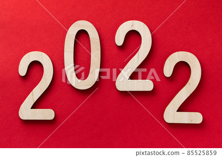 2022 year wooden numbers lying on the red paper background with shadows 85525859
