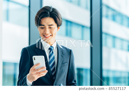 Young businessman with a smartphone shooting cooperation "LINK FOREST" Young businessman with a smartphone shooting cooperation "LINK FOREST" 85527117