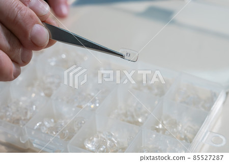 Installation of nose pads in glasses. A male technician repairs broken glasses 85527287