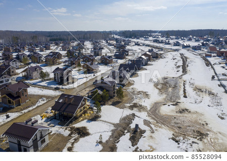 Aerial view of a cottage settlement under construction in the forest in Siberia in spring Aerial view of a cottage settlement under construction in the forest in Siberia in spring 85528094