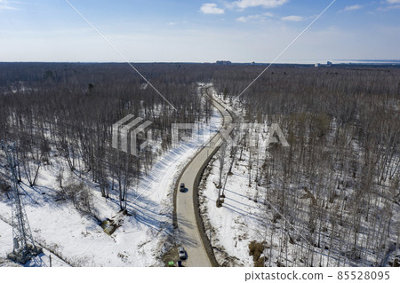 Aerial view of a winding road in a forest in Siberia in winter Aerial view of a winding road in a forest in Siberia in winter 85528095