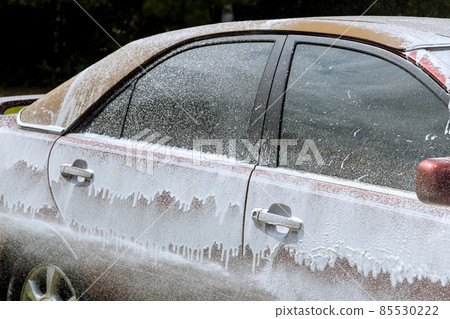 Cleaning the car with foam car wash in self service Cleaning the car with foam car wash in self service 85530222