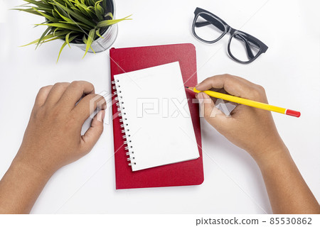 Hand with pencil writing in note book 85530862