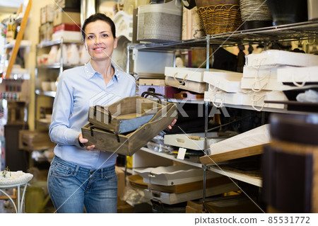 Positive female holding boxes in home decor store 85531772