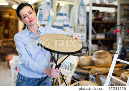 Woman customer choosing wooden stool Woman customer choosing wooden stool 85531856