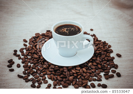 Cup of coffee and roasted beans on beige background 85533047