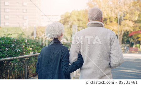 Senior couple walking snuggling up 85533461