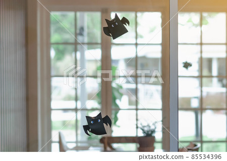 Origami bat made of black paper hanging on a rope for Halloween decorations. Dark paper ghost Halloween party concept origami paper bat. The figure of black paper bat flying over room. Selective focus Origami bat made of black paper hanging on a rope for Halloween decorations. Dark paper ghost Halloween party concept origami paper bat. The figure of black paper bat flying over room. Selective focus 85534396