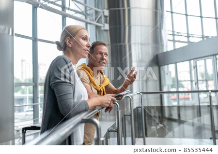 Male talking to his pensive female companion at the airport 85535444