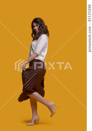 Trendy lady in a long pleated skirt enjoying her dance Trendy lady in a long pleated skirt enjoying her dance 85535896