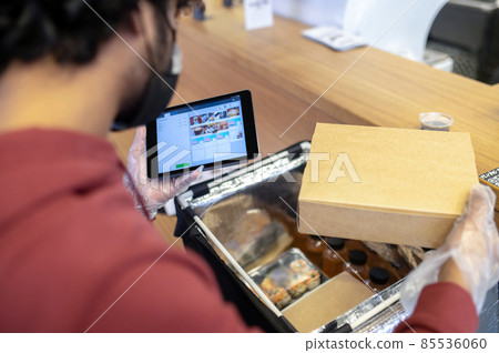 Courrier checking the order for food delivery Courrier checking the order for food delivery 85536060