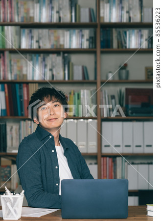 A man writing in front of a computer A man writing in front of a computer 85536223