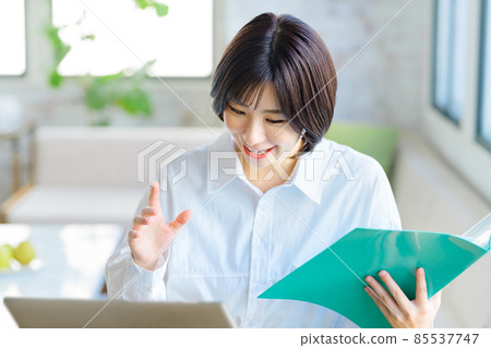 一位從事遠程辦公的年輕女商人在客廳裡與文件聊天時解釋 一位從事遠程辦公的年輕女商人在客廳裡與文件聊天時解釋 85537747