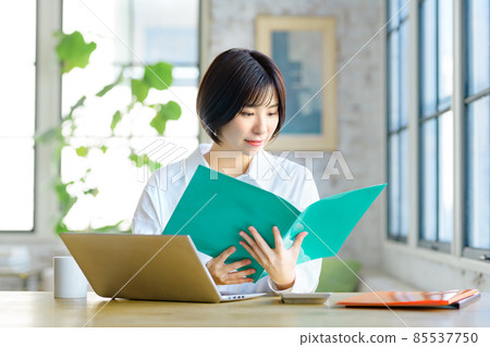 一位從事遠程辦公的年輕女商人在客廳裡與文件聊天時解釋 一位從事遠程辦公的年輕女商人在客廳裡與文件聊天時解釋 85537750