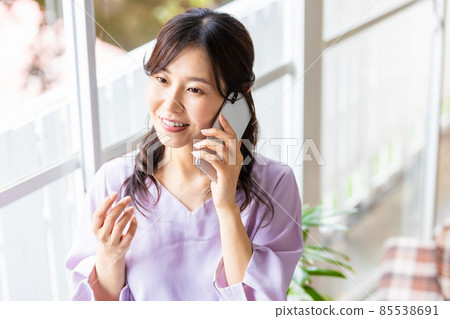 A woman talking on a smartphone A woman talking on a smartphone 85538691