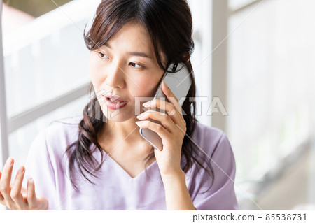 A woman talking on a smartphone A woman talking on a smartphone 85538731