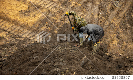 a worker with a metal detector is looking for valuable artifacts at an archaeological site 85538897