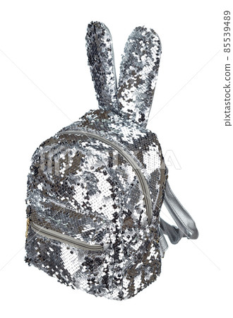 Backpack is embroidered with silver shiny sequins, with decorative rabbit ears, with a zipper, with an external patch pocket isolated on a white background. Backpack is embroidered with silver shiny sequins, with decorative rabbit ears, with a zipper, with an external patch pocket isolated on a white background. 85539489