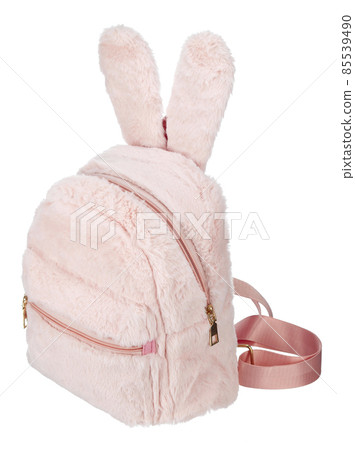 Backpack made of pink fur with decorative rabbit ears, with a zipper, with an external patch pocket isolated on a white background. Backpack made of pink fur with decorative rabbit ears, with a zipper, with an external patch pocket isolated on a white background. 85539490