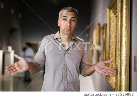 Adult man is visiting museum and looking at the pictures 85539998