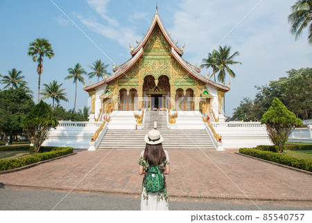 Back view of tourist woman looking to Haw Pha Bang an iconic landmark in the royal palace of Luang Prabang, the UNESCO world heritage site in north central Laos. 85540757