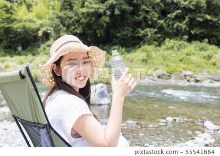 Girl drinking water at the camp 85541664