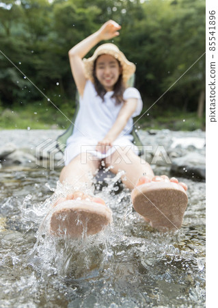 A girl playing with water splashes in the river A girl playing with water splashes in the river 85541896