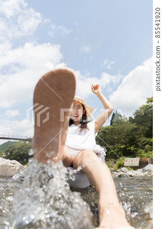 A girl playing with water splashes in the river A girl playing with water splashes in the river 85541920