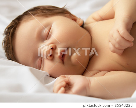 Small baby girl sleeping. Newborn baby in a wrap Small baby girl sleeping. Newborn baby in a wrap 85543223