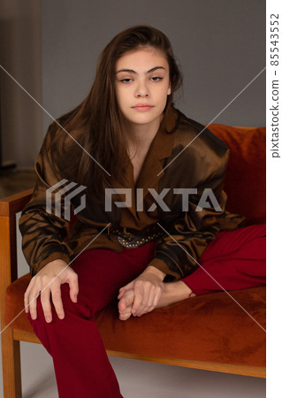 Dark hair young woman with dark grey wall behind Dark hair young woman with dark grey wall behind 85543552