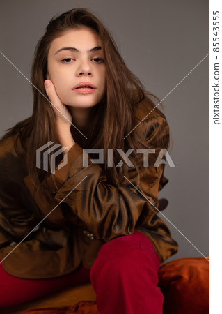 Dark hair young woman with dark grey wall behind Dark hair young woman with dark grey wall behind 85543555