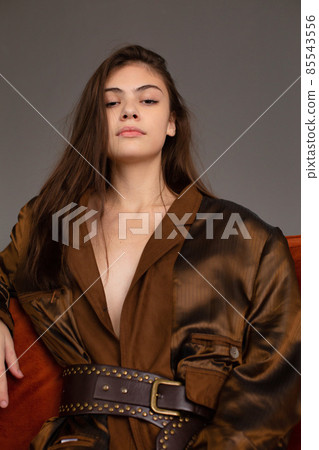 Dark hair young woman with dark grey wall behind Dark hair young woman with dark grey wall behind 85543556