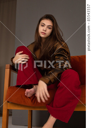 Dark hair young woman with dark grey wall behind 85543557
