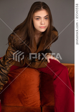 Dark hair young woman with dark grey wall behind Dark hair young woman with dark grey wall behind 85543558